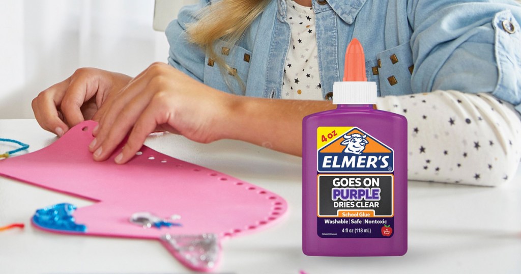 girl making a pink unicorn craft with a bottle of elmer's purple glue in front