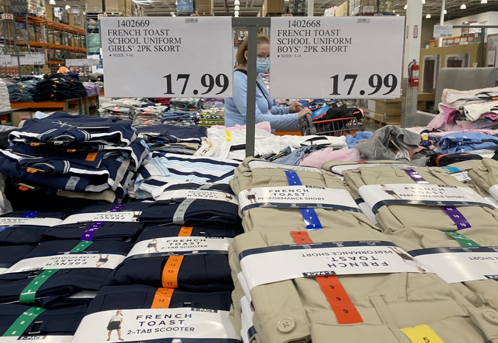 store display table full of navy and khaki colored kids uniform shorts and skorts