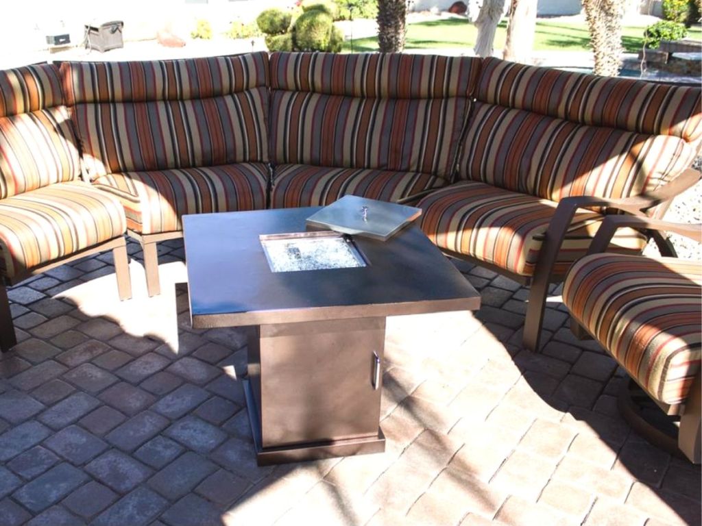 A fire table on a patio in front of patio furniture