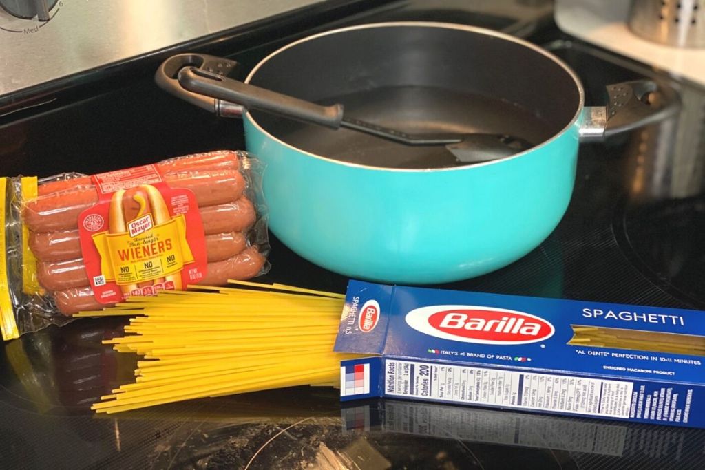 Spaghetti hot dog ingredients on a stovetop
