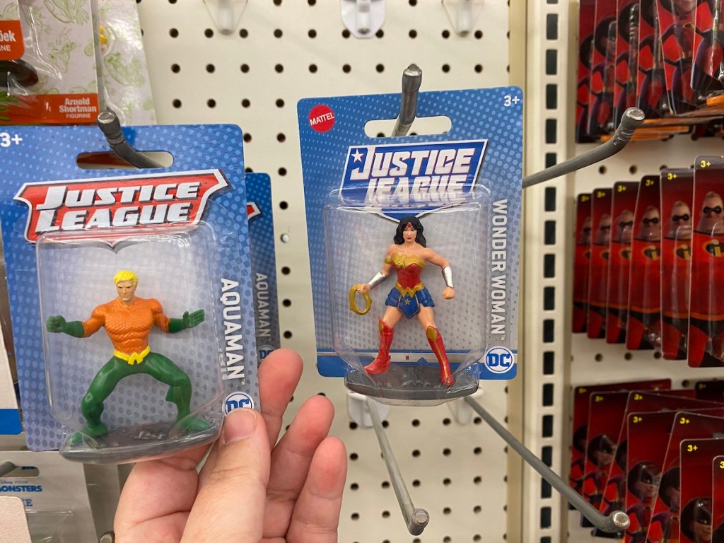 hand holding justice league aquaman with wonder woman figure