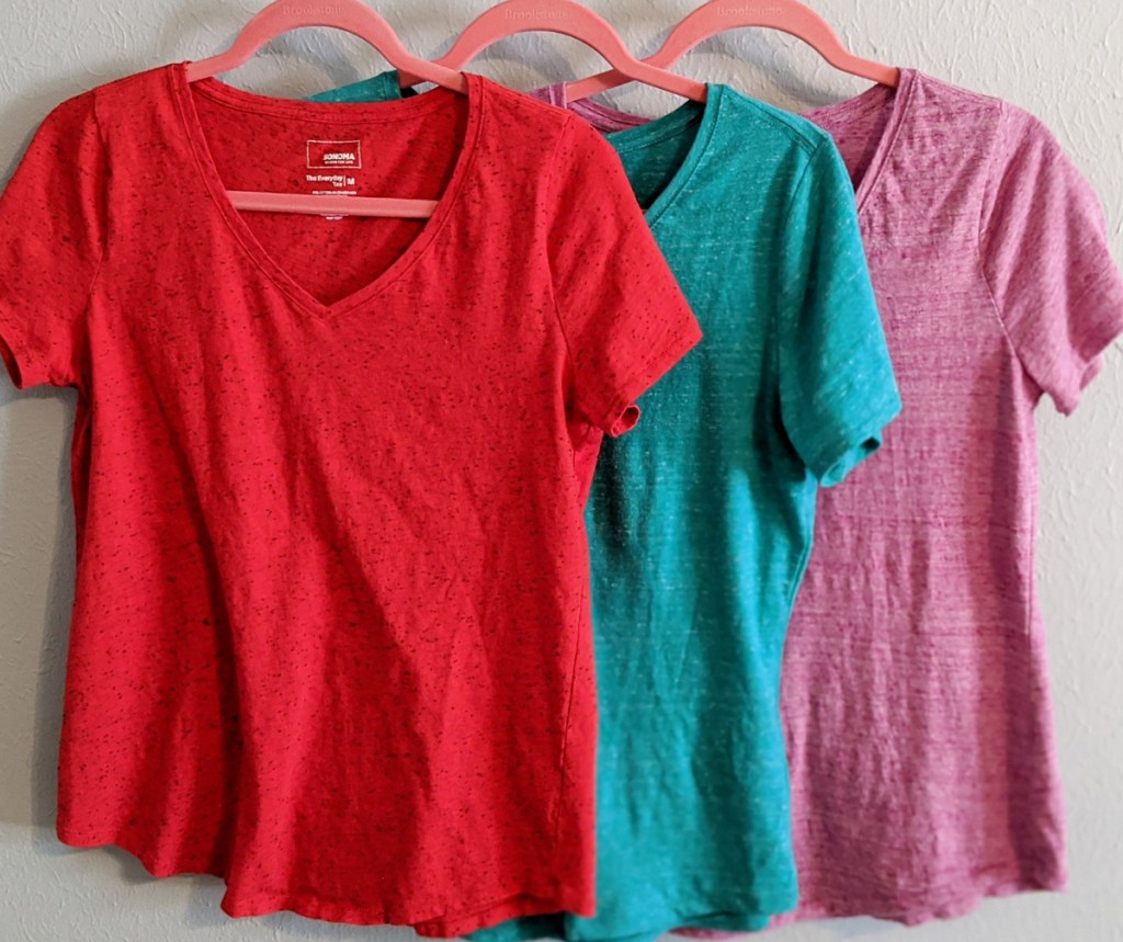 red, blue, and pink solid color basic tees hanging on pink hangers
