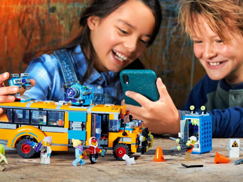 youngsters playing with a LEGO Hidden Side Paranormal Intercept Bus 3000 AR Building Kit