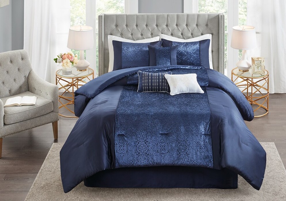 bed with blue comforter and white pillows
