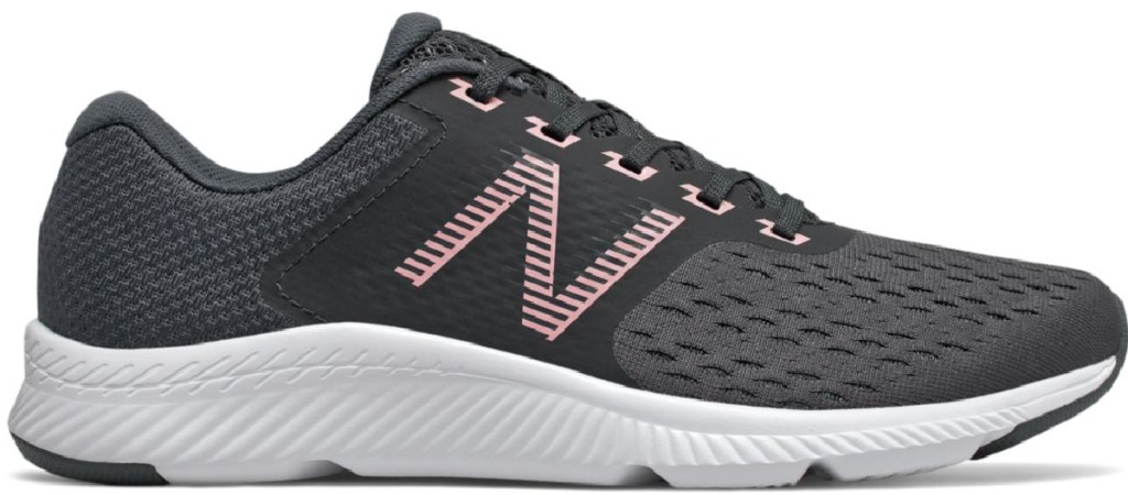 side view of black shoes with light pink new balance logo and white soles