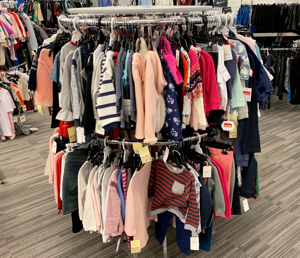 round store display rack with kids and baby apparel hanging on hangers