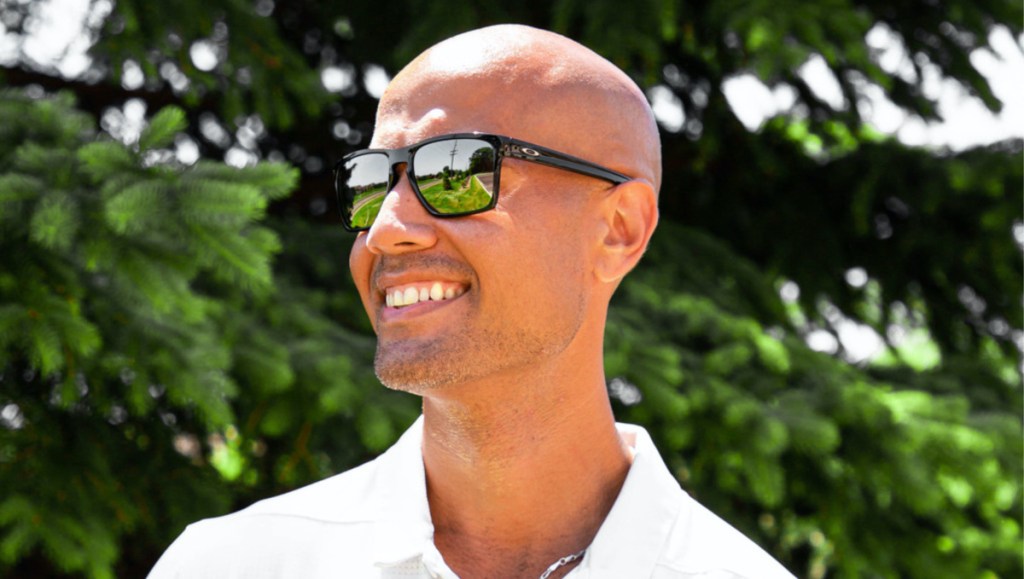 man smiling outside wearing black sunglasses