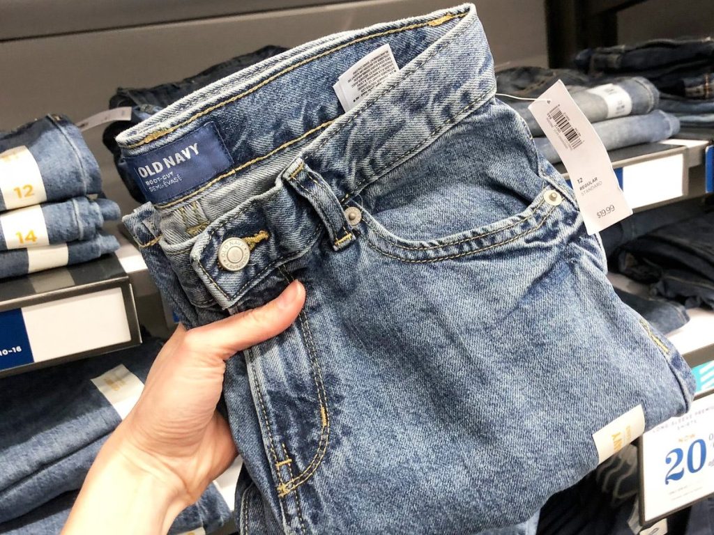 person holding up a pair of medium wash old navy boys jeans