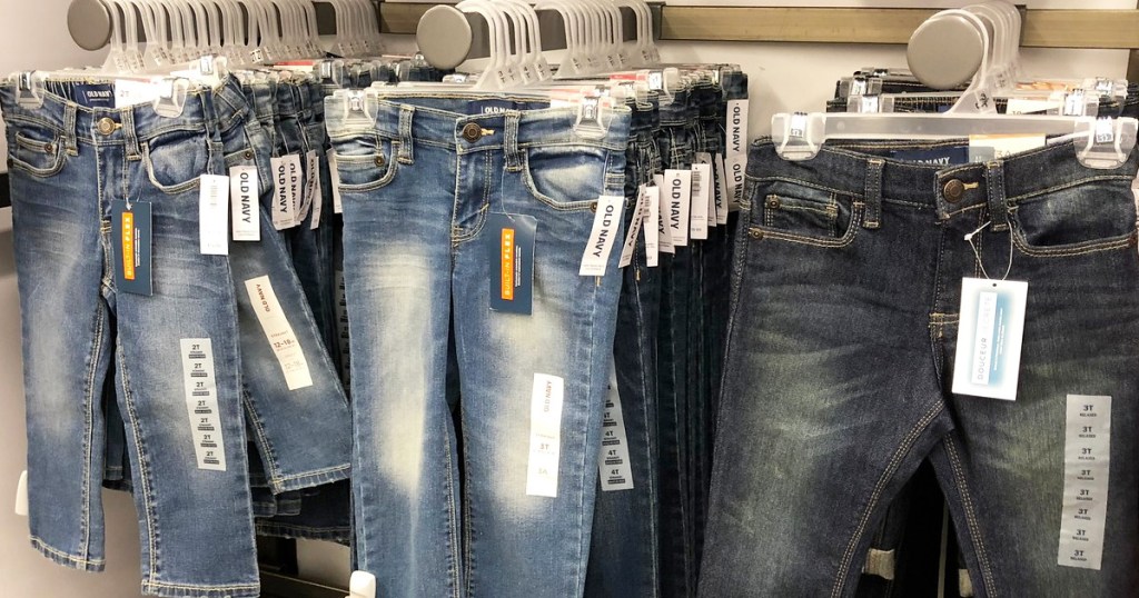 various washes of kids jeans hanging on hangers on store display