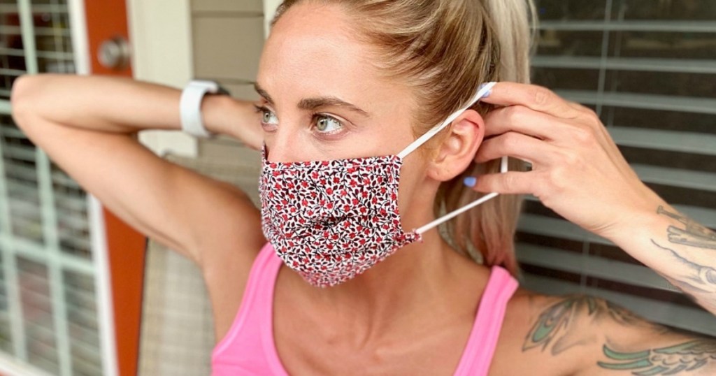woman putting on a floral print face mask
