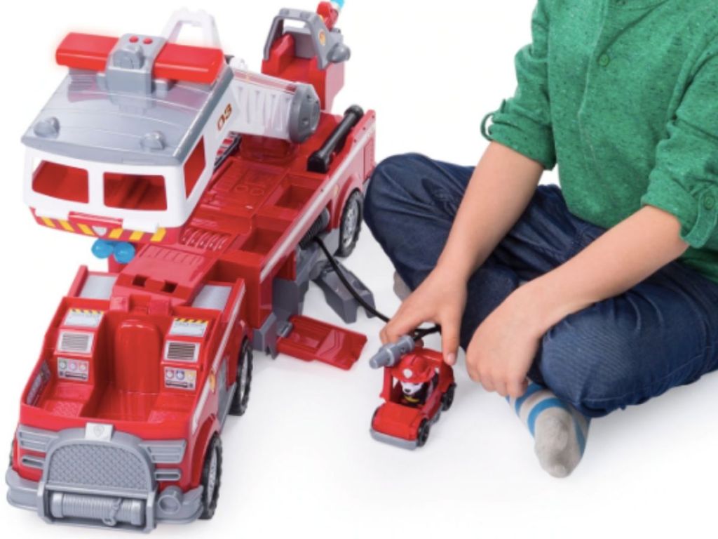 little boy with large toy fire truck