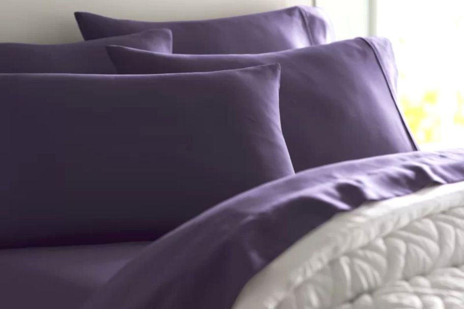 Purple sheets and pillowcases displayed on a made bed