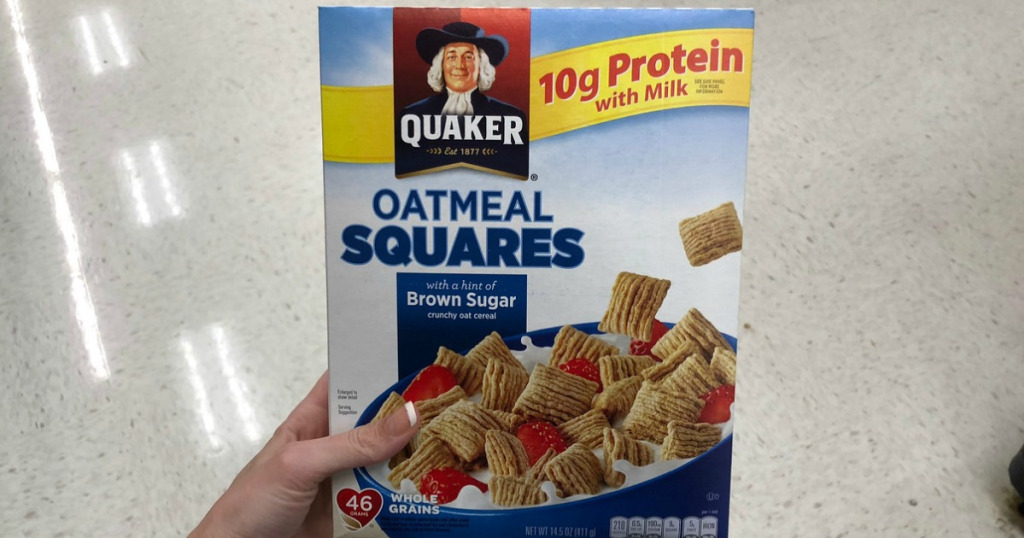 Hand holding a box of Quaker oatmeal squares breakfast cereal