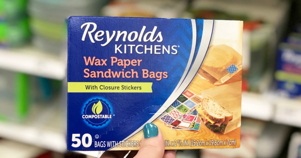 person with blue fingernails holding up a blue box of reynolds wax paper sandwich bags