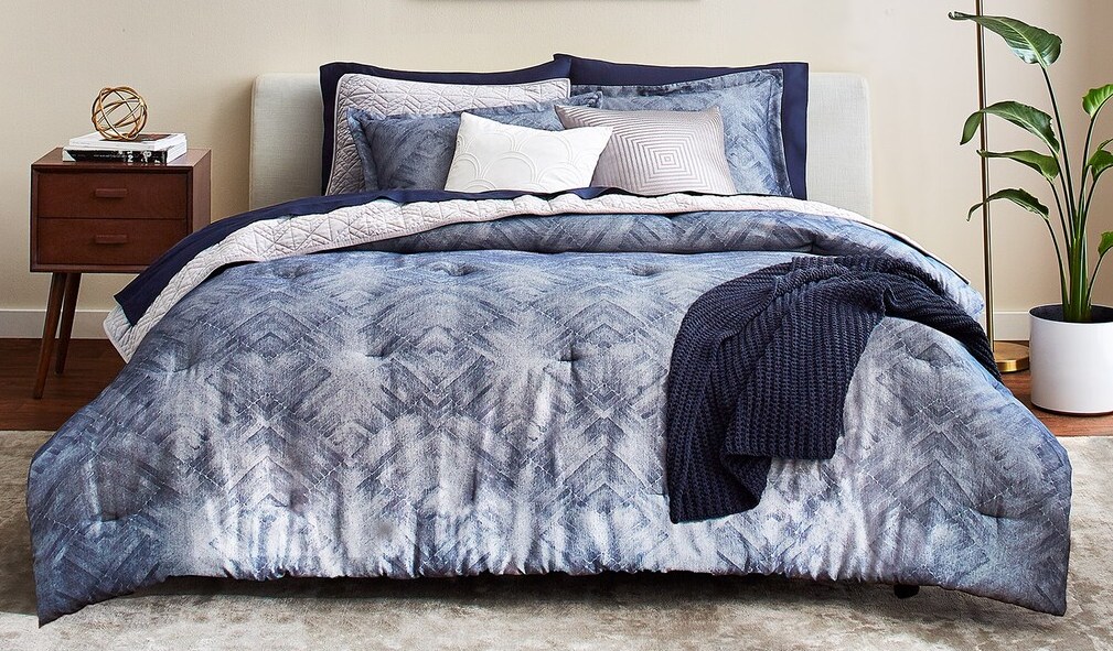 bed with a blue comforter and blanket