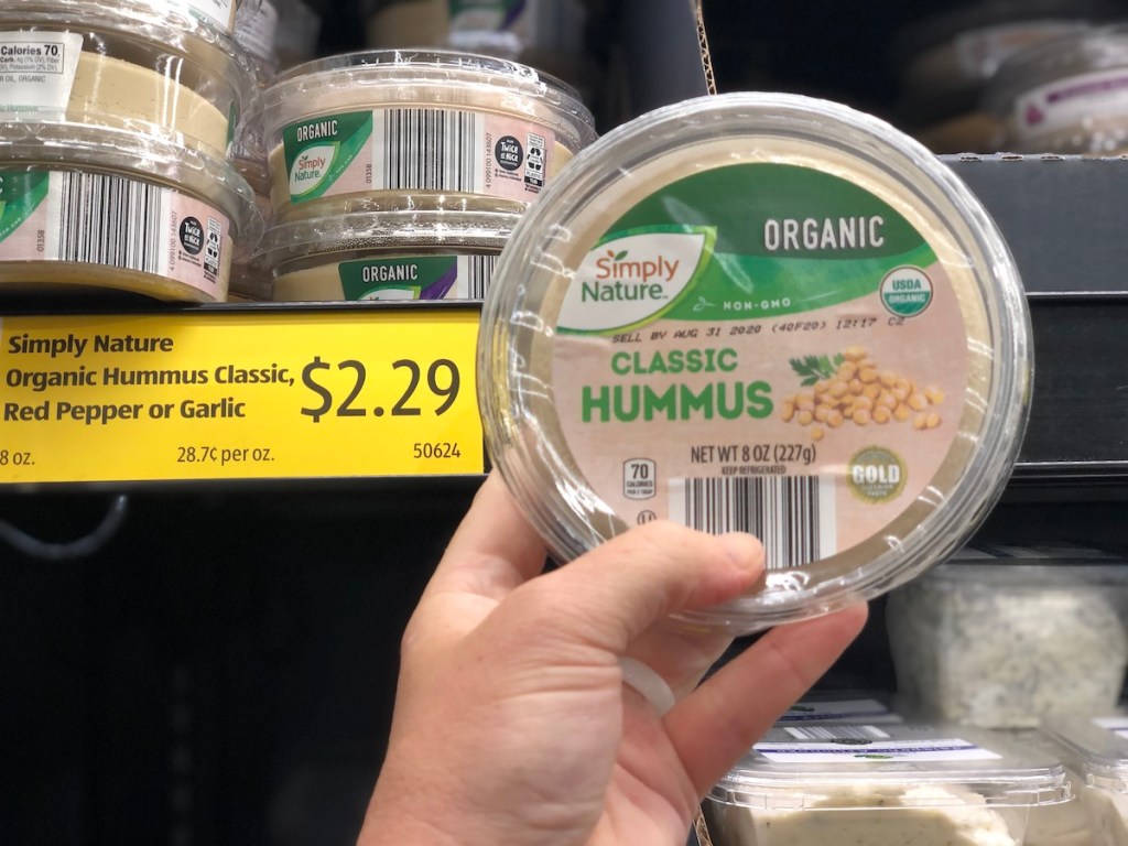 hand holding up Simply Nature Organic Hummus in store