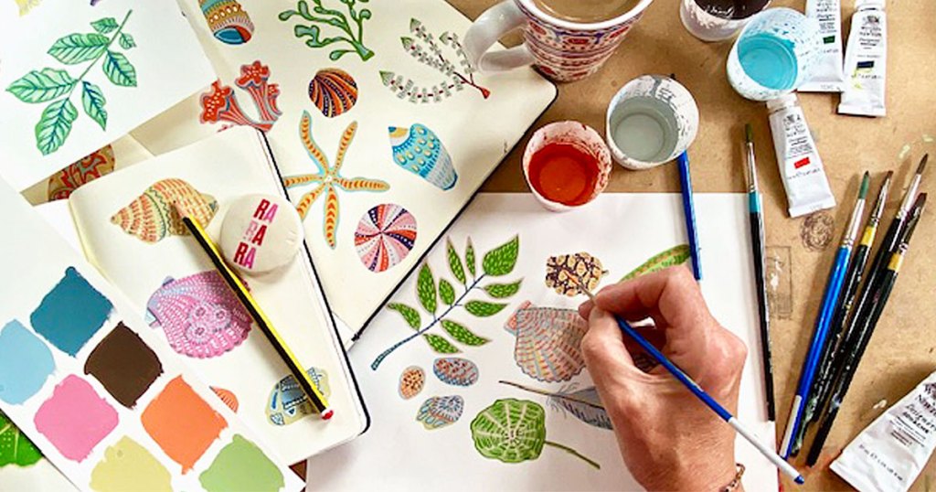 person using watercolors to paint floral designs