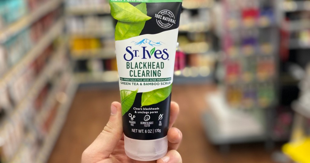 hand holding green tea face scrub in store aisle