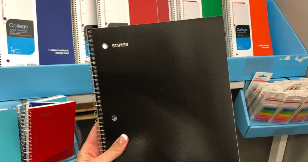 manicured hand holding black notebook in store
