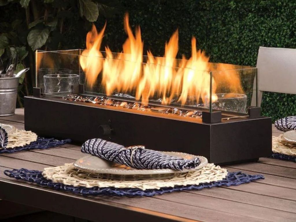 A tabletop fire pit on a table outside