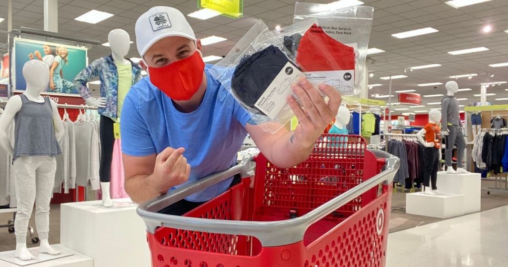 man wearing face mask in Target holding packages of reusable face masks