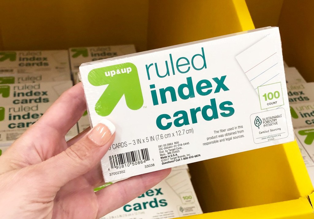 person holding a package of ruled index cards