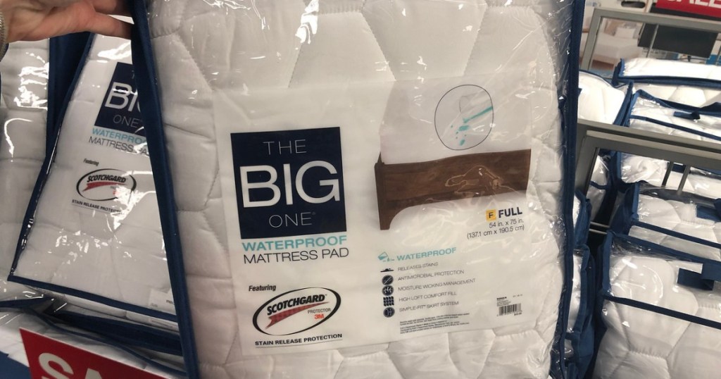 hand holding up The Big One Waterproof Mattress Pad Full Size in store