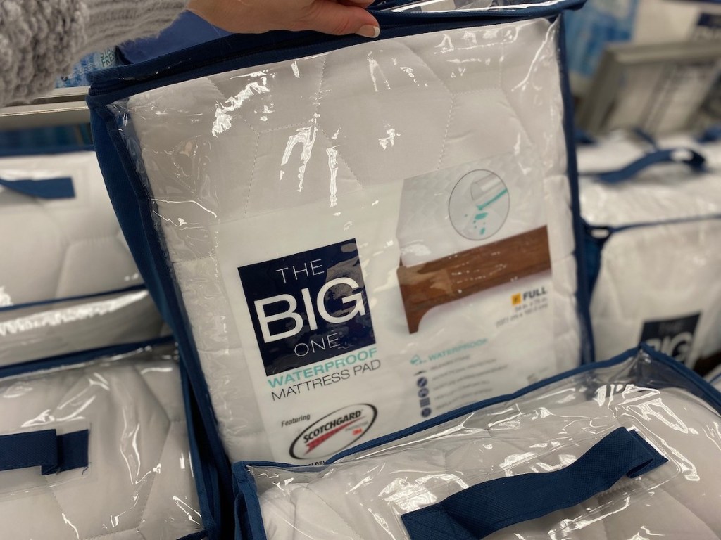 hand holding up the big one waterproof mattress pad in store