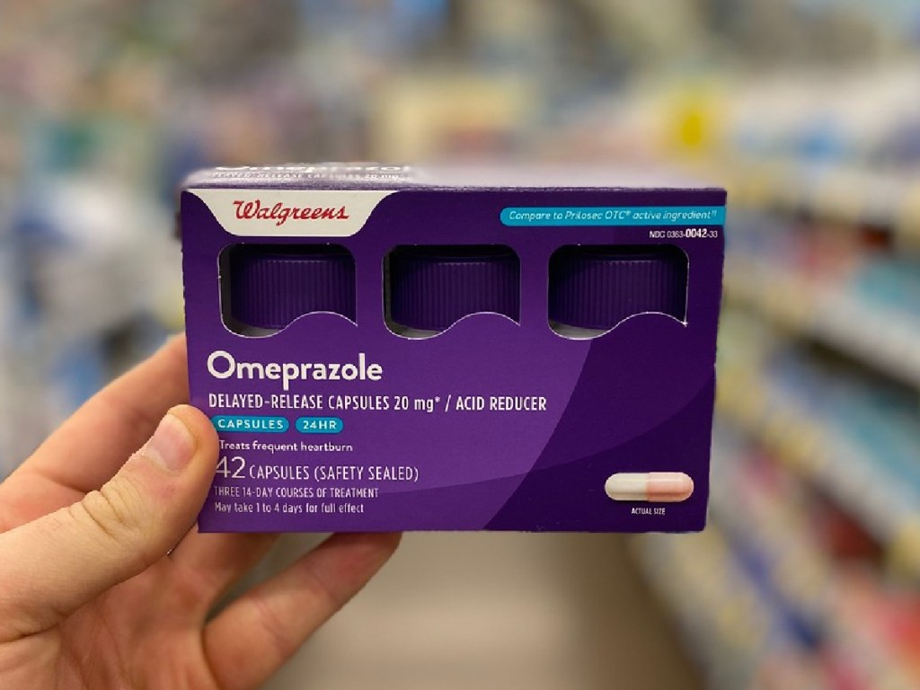 person holding Walgreens Omeprazole 42-Count 3-Pack