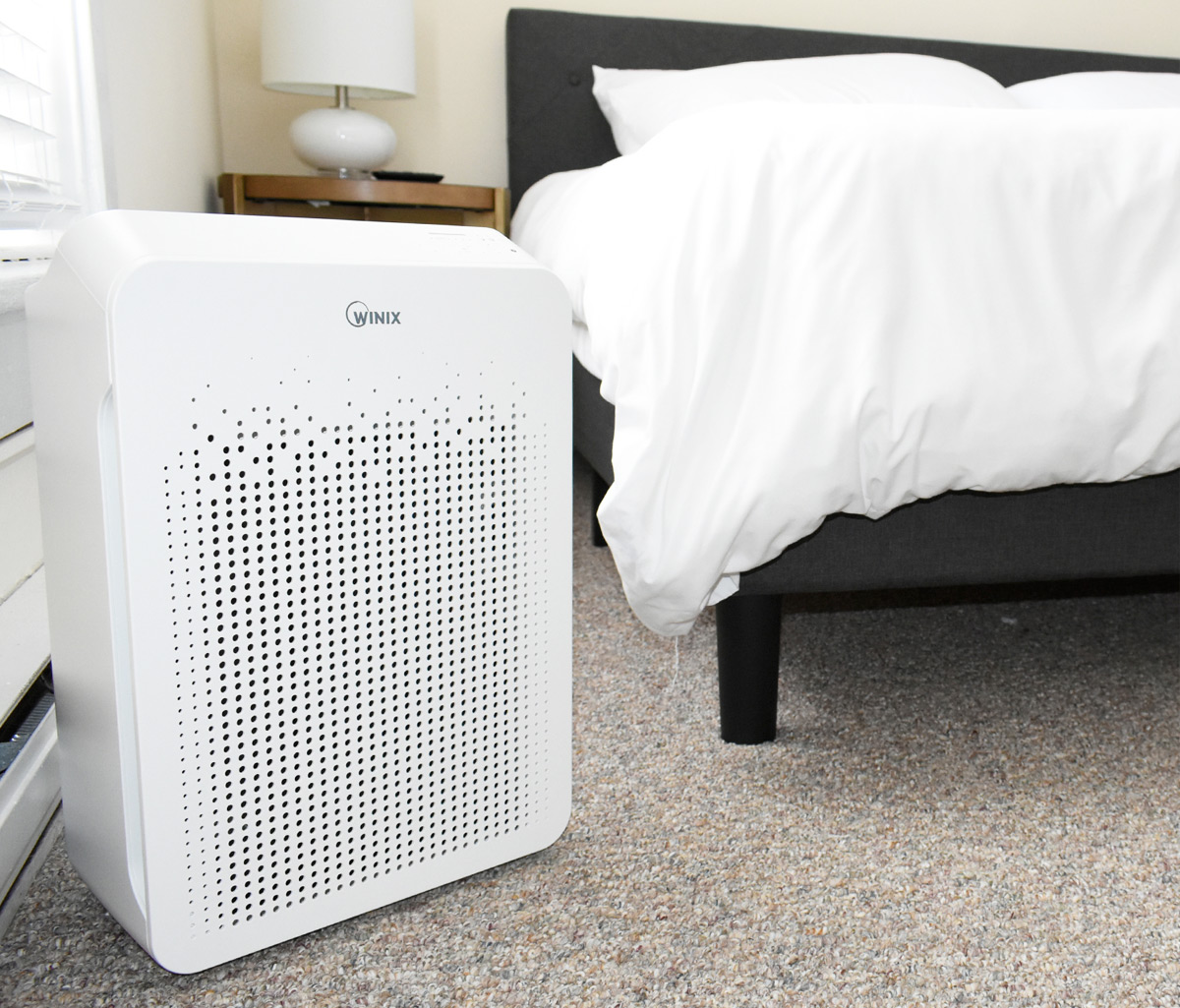 white rectangular air purifier on carpet in bedroom near bed