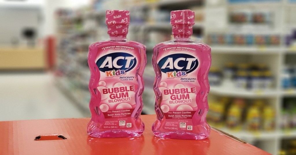 two bottles of act kids rinse, in store on a counter. They are the bubble gum flavor