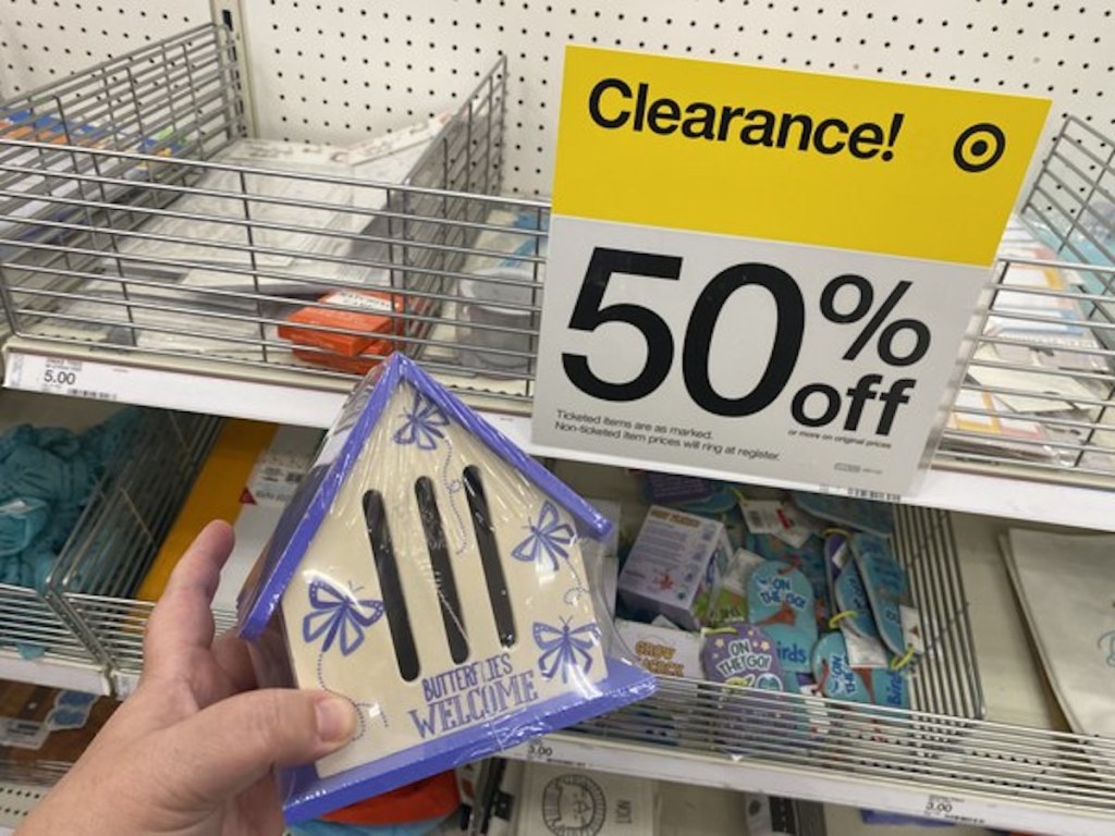 hand holding butterflies welcome wooden home next to clearance 50% off sign from the Target Bullseye