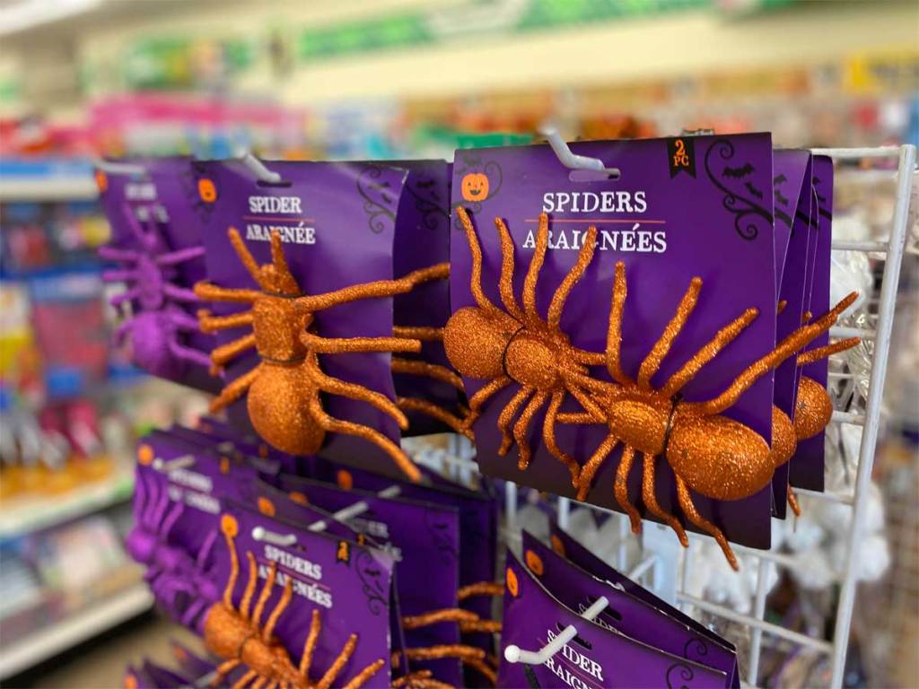 large plastic spiders covered in orange glitter on display in store