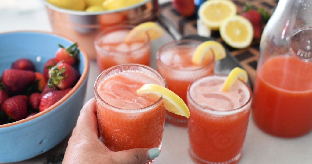 holding a glass with homemade strawberry lemonade
