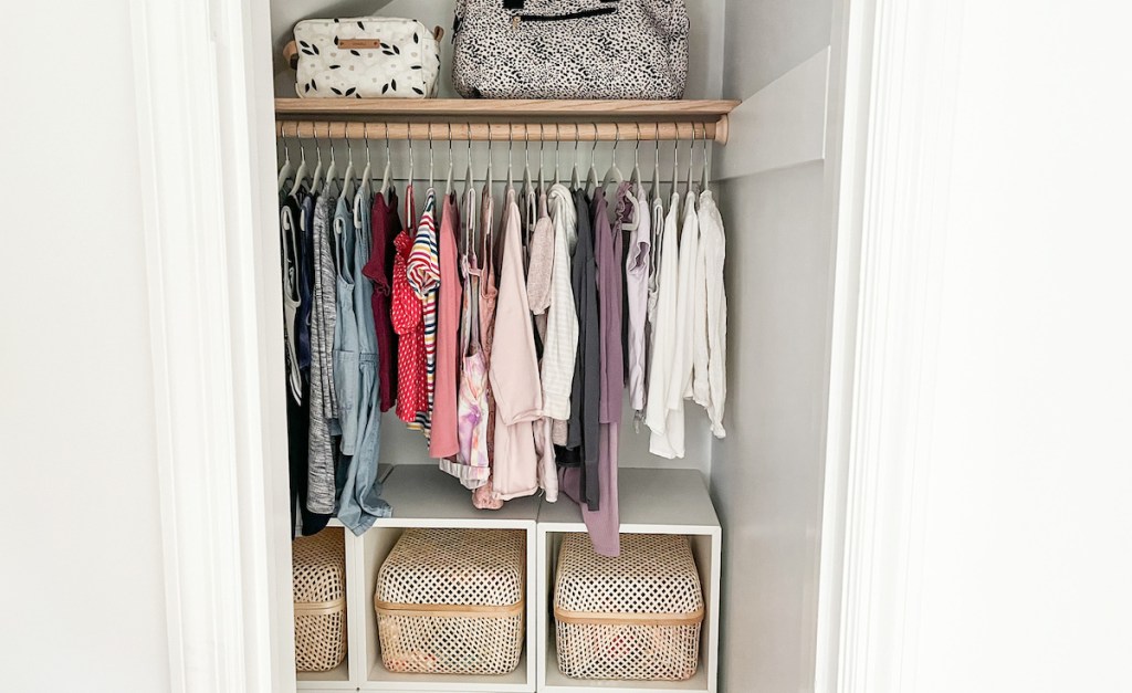 organized kids closet with hanging clothes and baskets