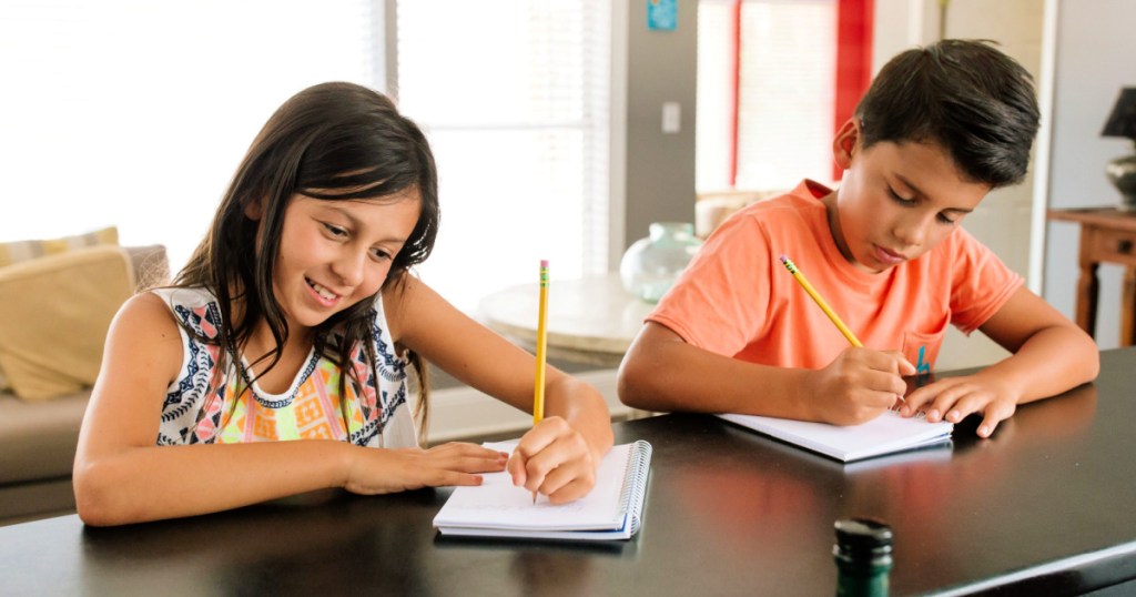 kids writing on notebook with a Ticonderoga pencil