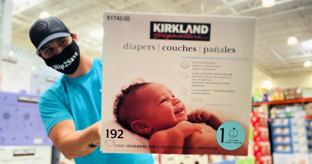 man holding box of kirkland diapers