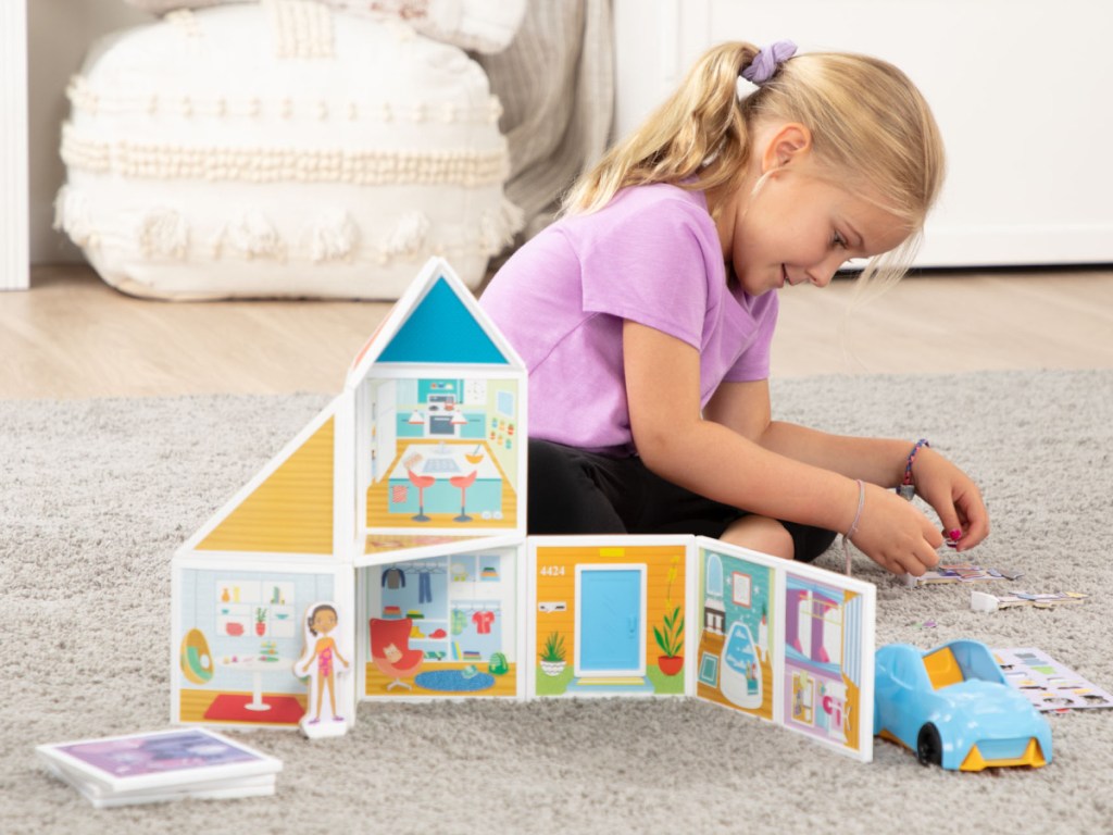 little girl playing with small toys to build a house