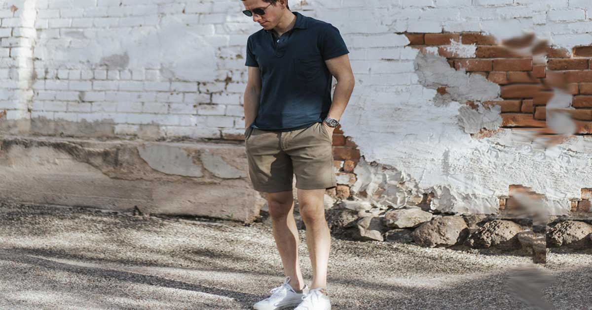 man wearing polo and shorts and white shoes outside