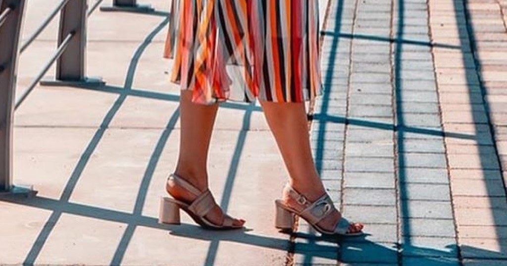 woman wearing pair of sandals on brick bridget