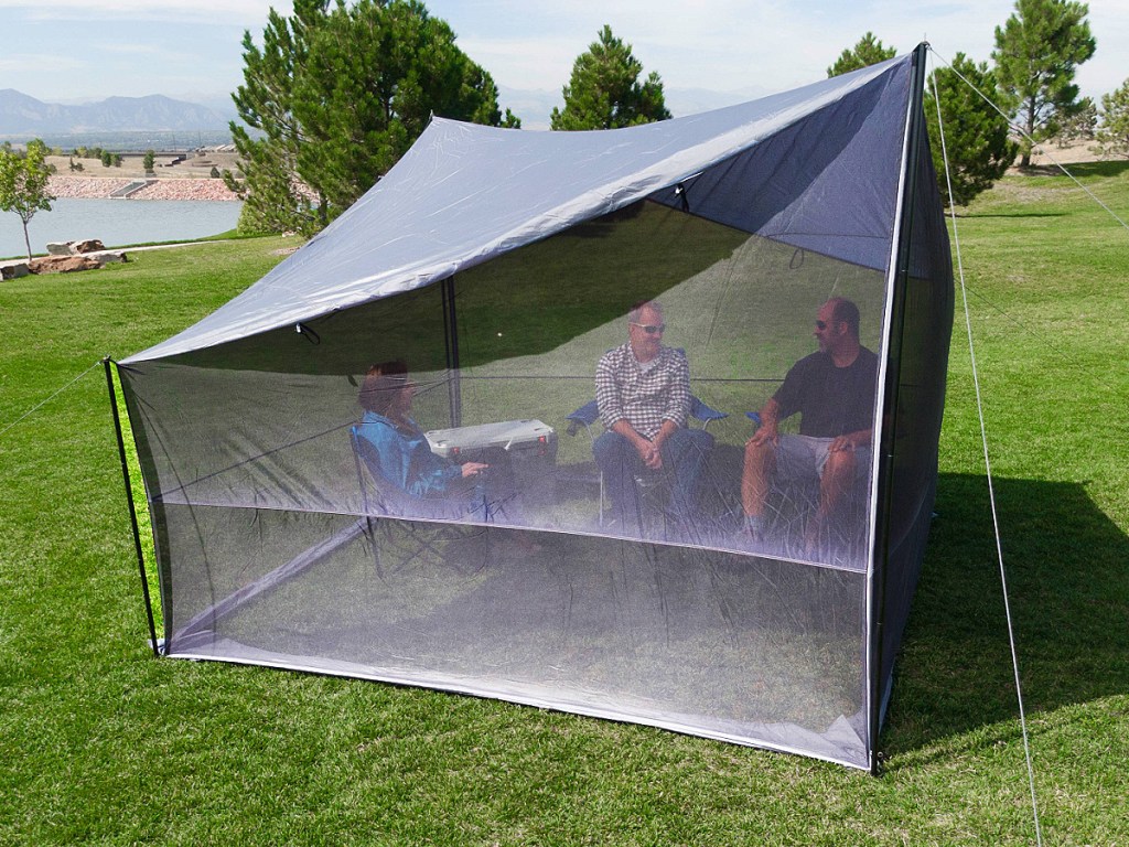 people sitting under a Ozark Trail Tarp Shelter with UV Protection and Roll-up Screen Walls