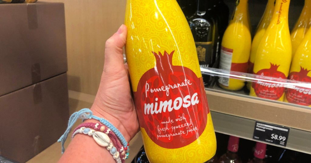 person holding bottle of pomegranate mimosa