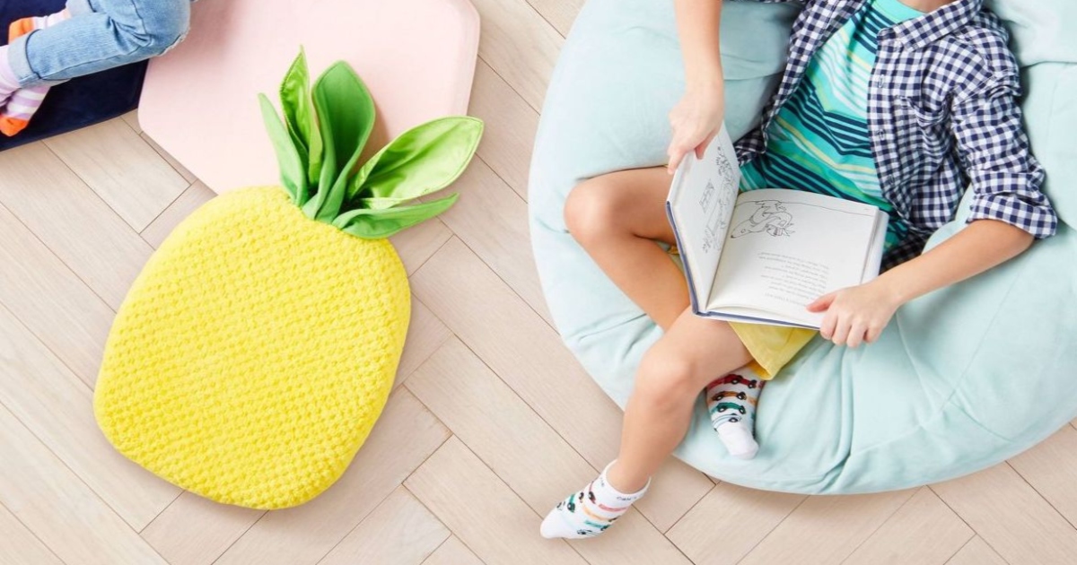pineapple floor cushion, on a floor between two kids reading books