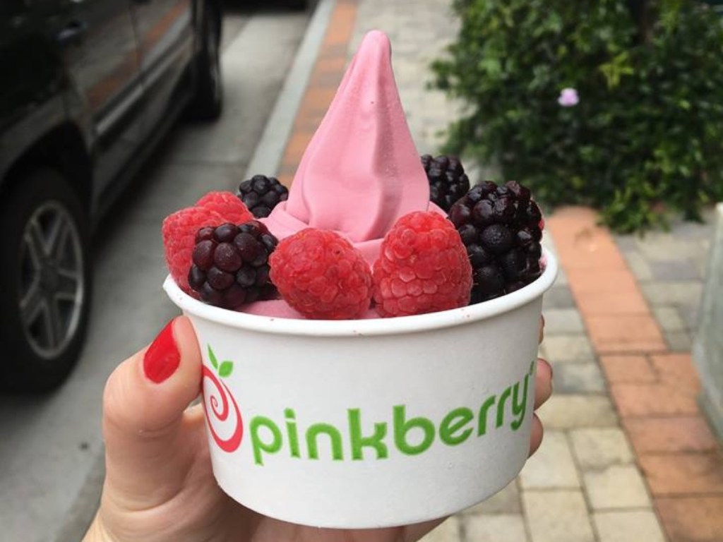 hand holding white cup of pinkberry frozen yogurt