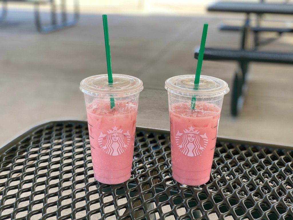 two starbucks pink drinks with straws