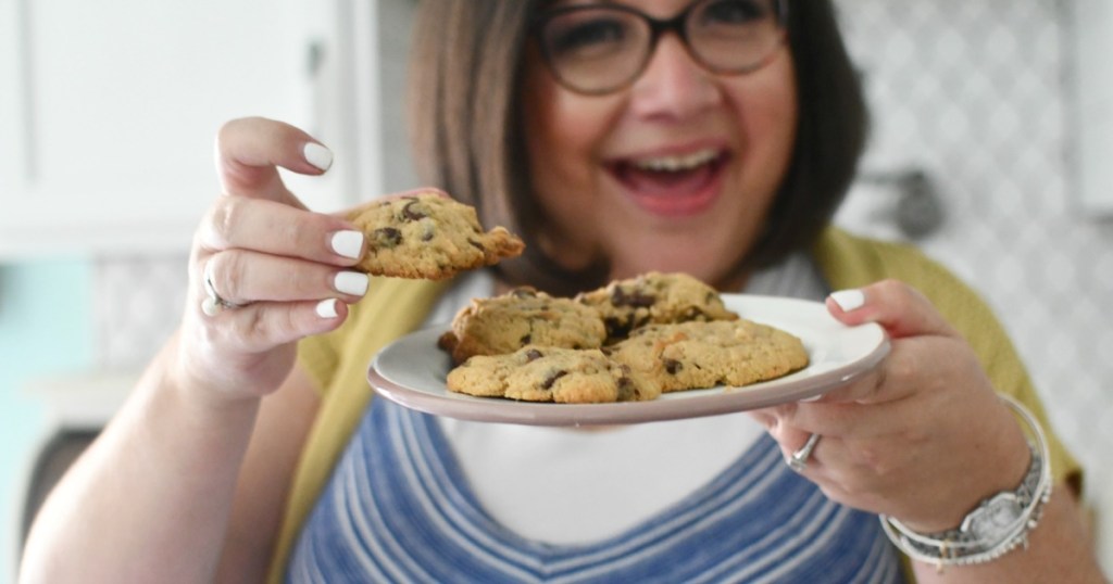 woman holding plate of sugar free chocolate chip cookies