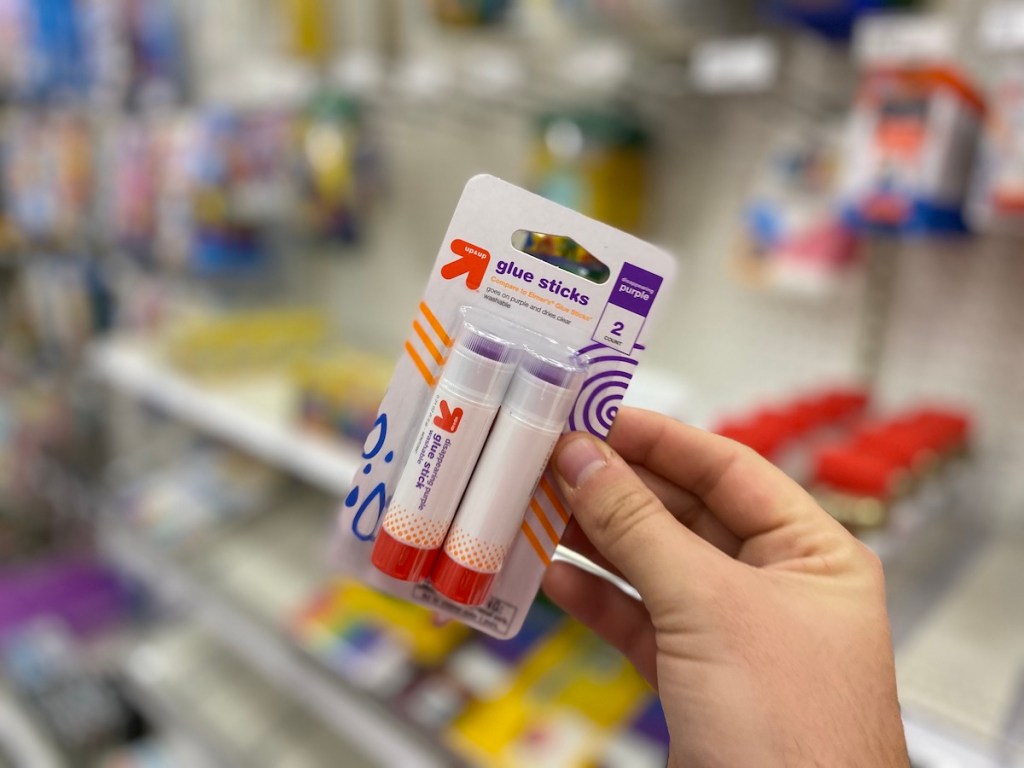 hand holding pack of up and up purple glue sticks
