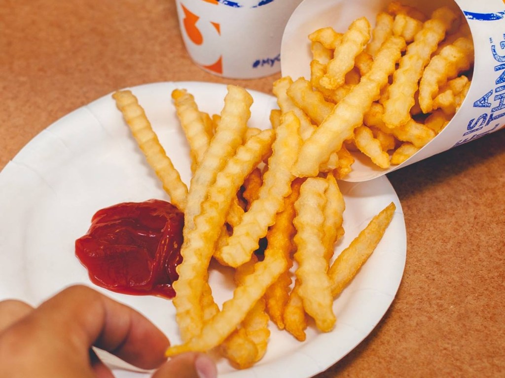 eating crinkle fries with ketchup