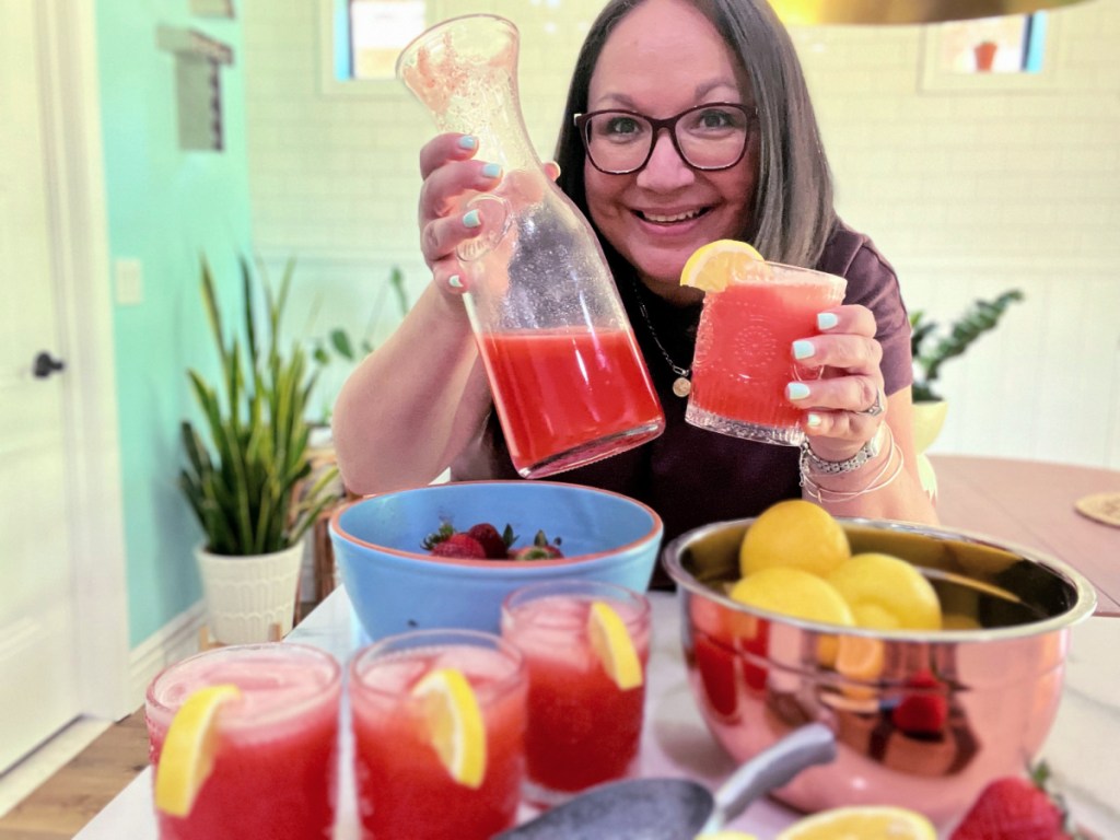 woman holding glass of strawberry lemonade