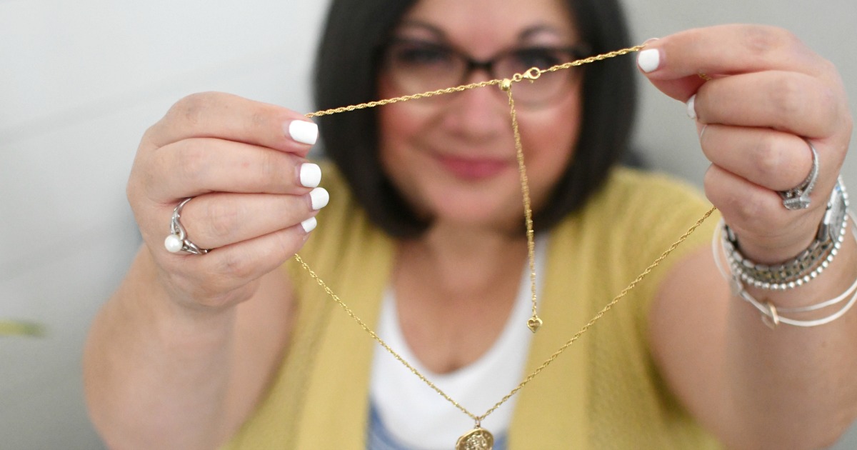 woman holding up a gold chain necklace from Roma Designer Jewelry